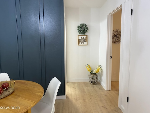 dining space with light wood-style flooring and baseboards