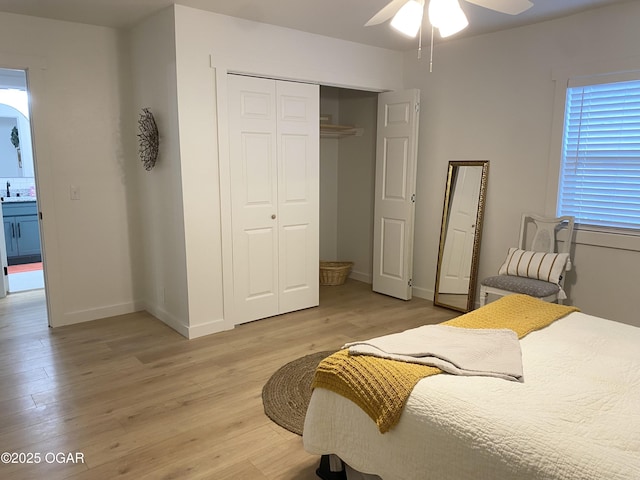 bedroom featuring baseboards, a closet, a ceiling fan, and light wood-style floors