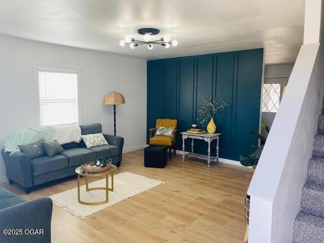 living room with a textured ceiling, stairway, plenty of natural light, and light wood-style floors