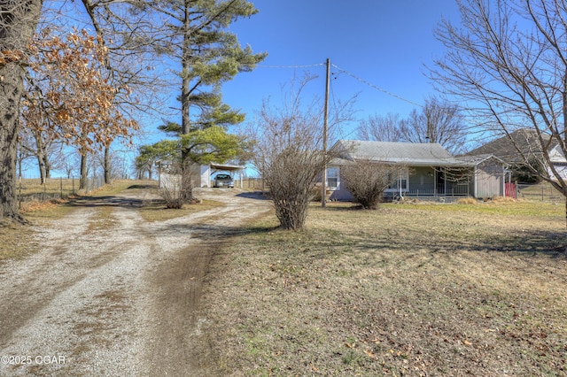 view of front facade with covered porch, driveway, and a front lawn