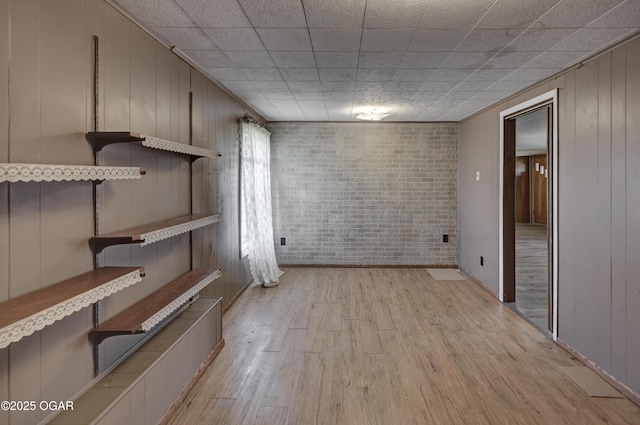 interior space with light wood-style floors and brick wall