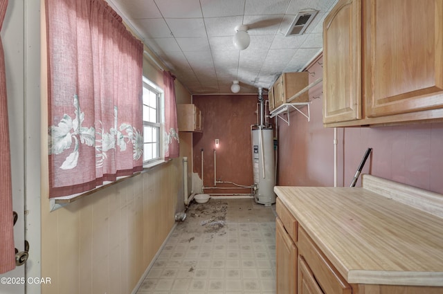 interior space featuring gas water heater, visible vents, and light floors