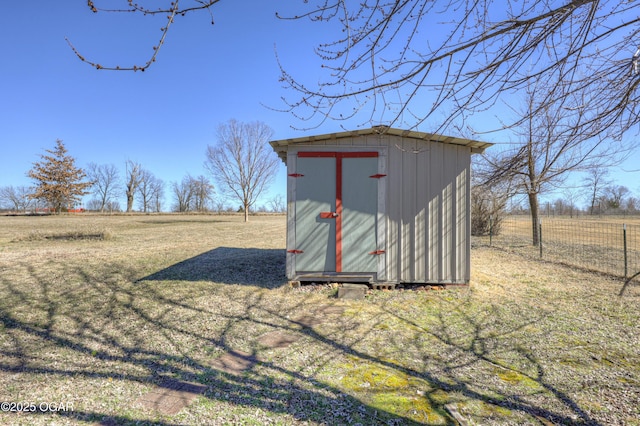 view of shed featuring a rural view and fence