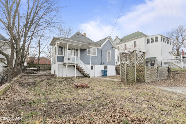 rear view of property with a fenced backyard, a chimney, and stairs