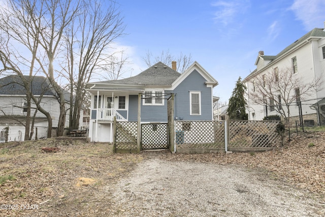 view of front of home with a porch, fence, stairway, and a shingled roof