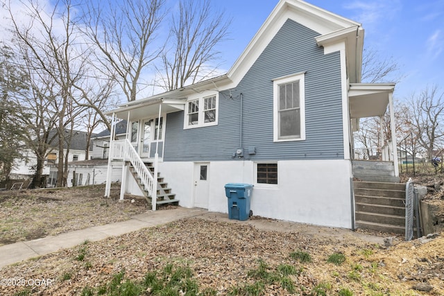 view of property exterior with covered porch and stairway