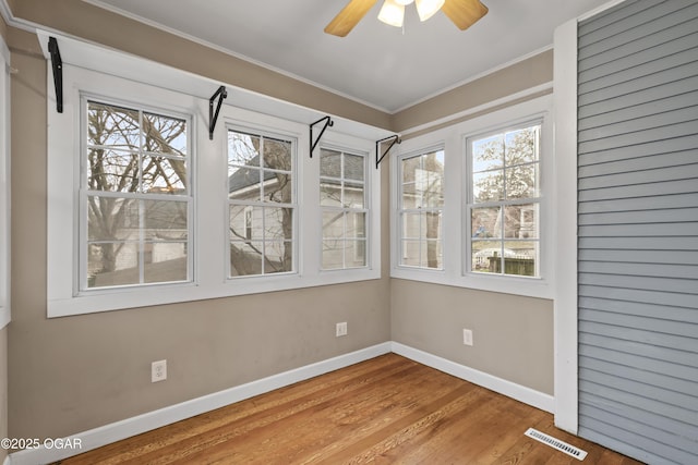 unfurnished sunroom featuring ceiling fan and visible vents