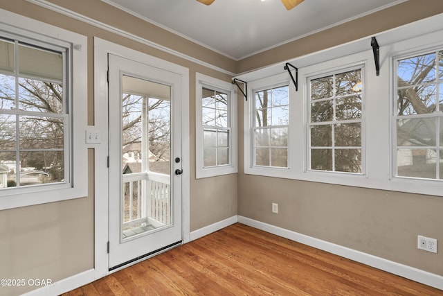 entryway with ornamental molding, a ceiling fan, baseboards, and wood finished floors