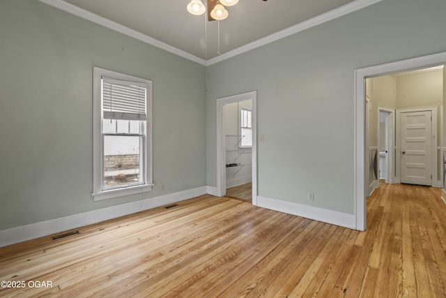 unfurnished bedroom featuring baseboards, light wood-type flooring, visible vents, and crown molding