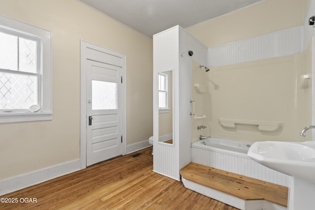 full bathroom featuring toilet, shower / bath combination, a sink, wood finished floors, and baseboards