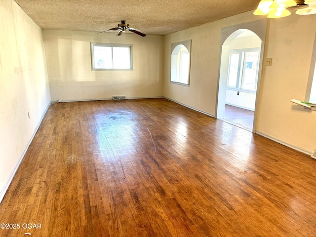 spare room featuring visible vents, plenty of natural light, and wood finished floors