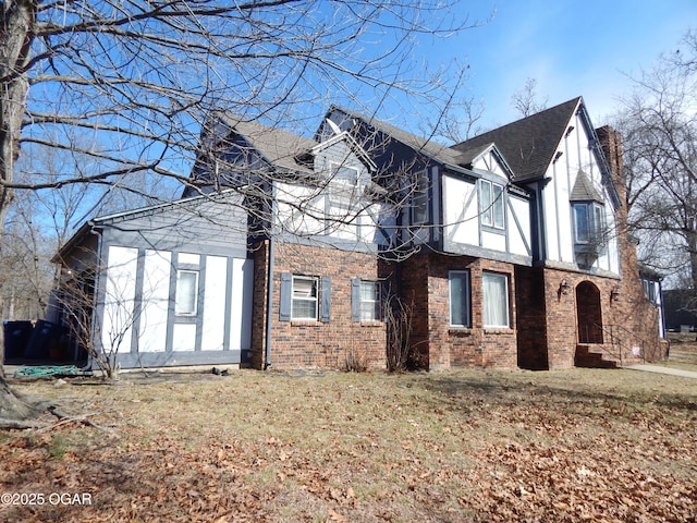 view of home's exterior with a yard, a shingled roof, stucco siding, and brick siding