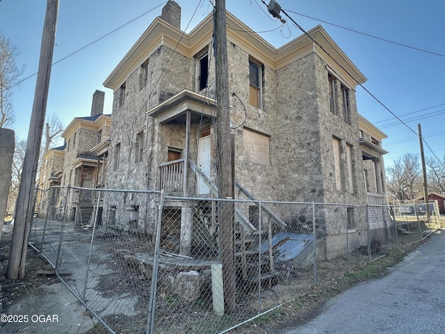 view of property exterior with a chimney and a fenced front yard