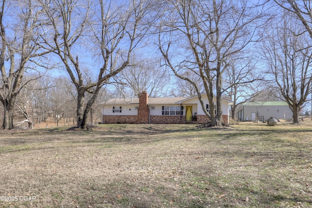 single story home with brick siding, a chimney, and a front yard