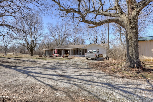 view of front of house with driveway and a sunroom