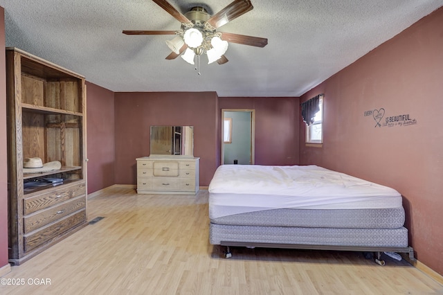 bedroom featuring a textured ceiling, ceiling fan, wood finished floors, and visible vents