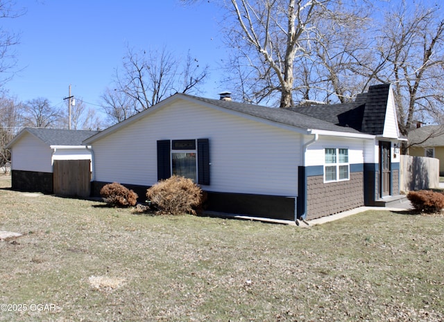 view of property exterior featuring a yard and a shingled roof