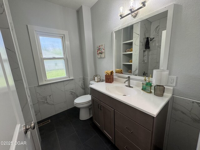 1711 Missouri Ave, Joplin, MO 64804 - full bathroom with vanity, a wainscoted wall, a shower, a textured wall, and tile walls