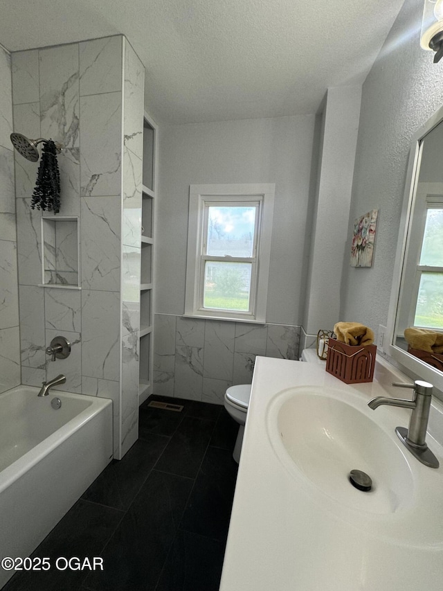 1711 Missouri Ave, Joplin, MO 64804 - bathroom featuring a textured ceiling, vanity, tile walls, shower / bathtub combination, and marble finish flooring