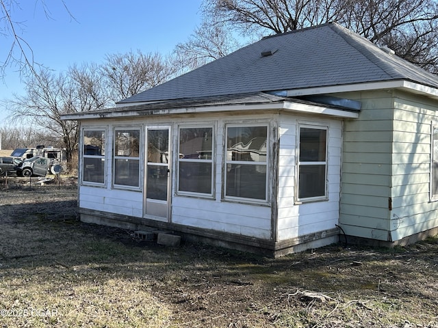 back of property with a shingled roof