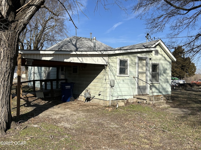 back of house featuring dirt driveway