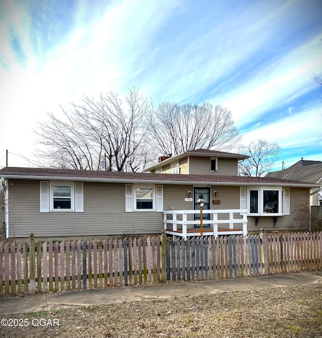 view of front of home with a fenced front yard and a chimney