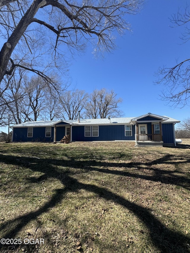 view of front facade featuring metal roof and a front lawn