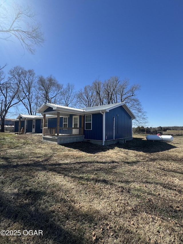 manufactured / mobile home with a porch, a front lawn, and board and batten siding