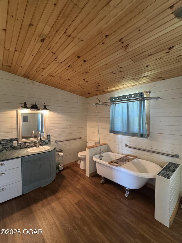 bathroom with toilet, wood finished floors, wood ceiling, vanity, and a freestanding bath