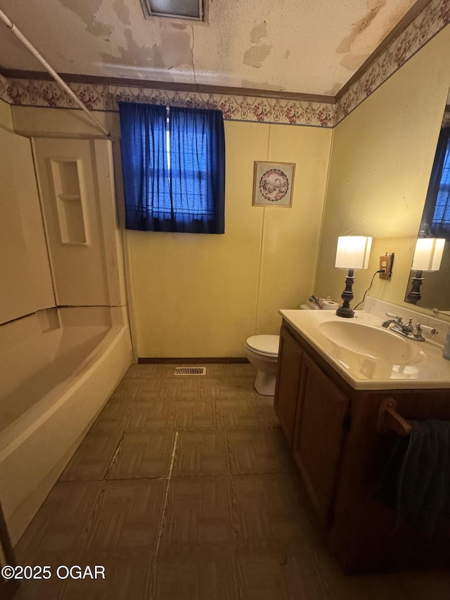 full bath with a textured ceiling, shower / washtub combination, vanity, and toilet