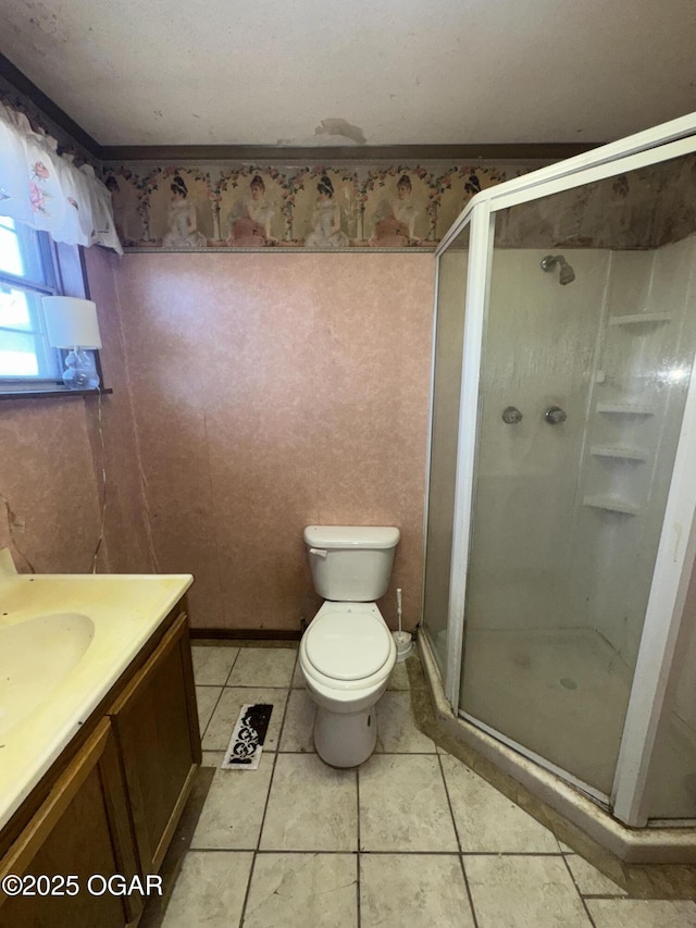 bathroom with a stall shower, vanity, toilet, and tile patterned floors