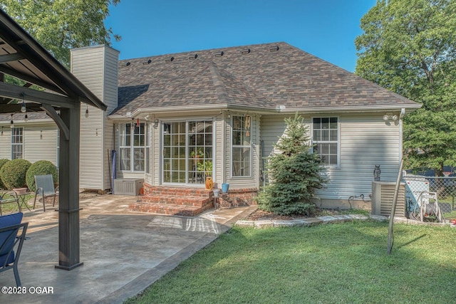 107 Oak Leaf Ter, Joplin, MO 64804 - back of property with entry steps, a shingled roof, a lawn, a chimney, and a patio area