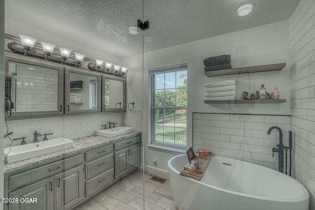 107 Oak Leaf Ter, Joplin, MO 64804 - full bath with a freestanding tub, visible vents, a sink, and double vanity