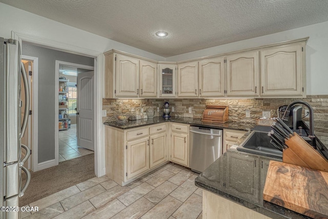 107 Oak Leaf Ter, Joplin, MO 64804 - kitchen with cream cabinetry, appliances with stainless steel finishes, decorative backsplash, and dark stone countertops