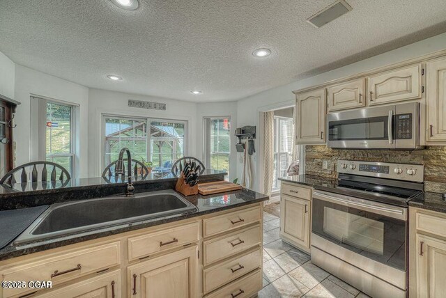 107 Oak Leaf Ter, Joplin, MO 64804 - kitchen with appliances with stainless steel finishes, light brown cabinets, a sink, and decorative backsplash
