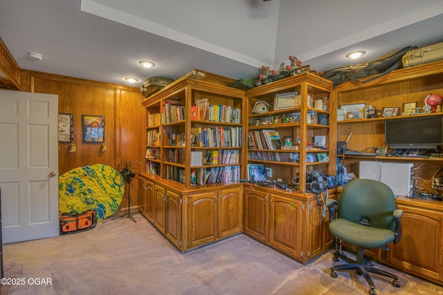 carpeted office space with built in desk and wooden walls