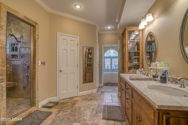 full bathroom with crown molding, stone tile flooring, a sink, a shower stall, and baseboards