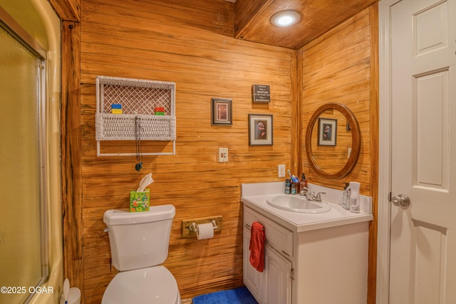 full bath with toilet, wooden walls, a shower, and vanity