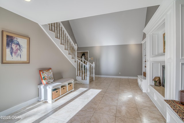 entrance foyer featuring lofted ceiling, stairs, baseboards, and tile patterned floors