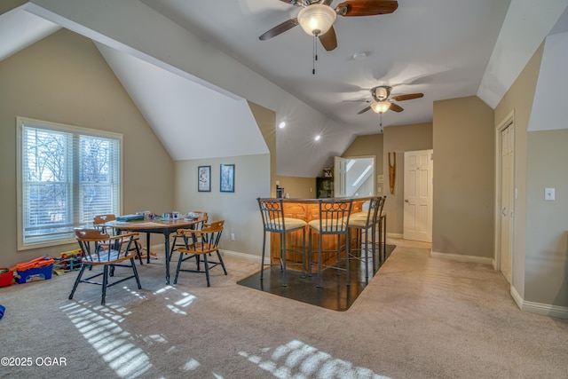 dining area with carpet floors, lofted ceiling, and baseboards