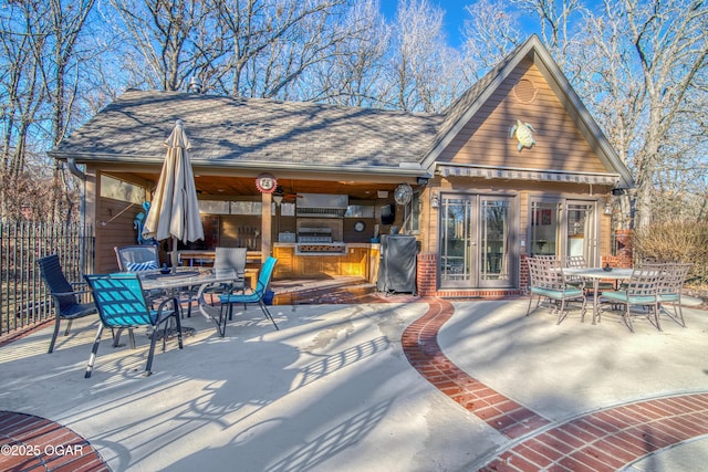 view of patio / terrace with outdoor dining space, grilling area, fence, and an outdoor structure