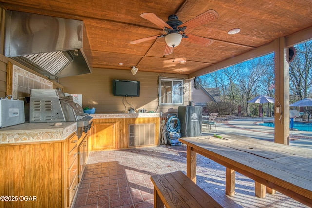 view of patio with a pool, area for grilling, and a ceiling fan