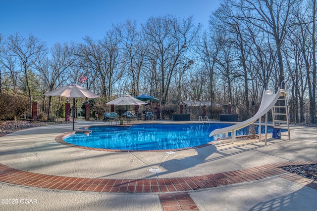 view of swimming pool featuring a water slide, a patio area, fence, and a fenced in pool