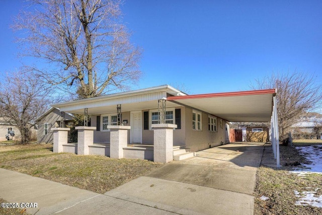 view of front of property with a porch, an attached carport, driveway, and stucco siding