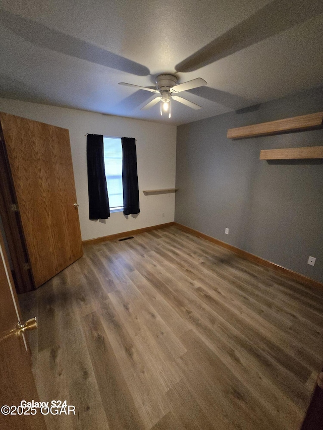 unfurnished bedroom with a ceiling fan, baseboards, and wood finished floors