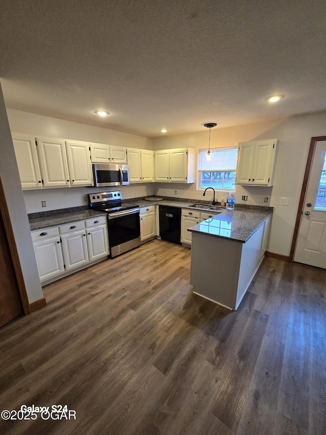 kitchen featuring stainless steel appliances, white cabinetry, and a peninsula