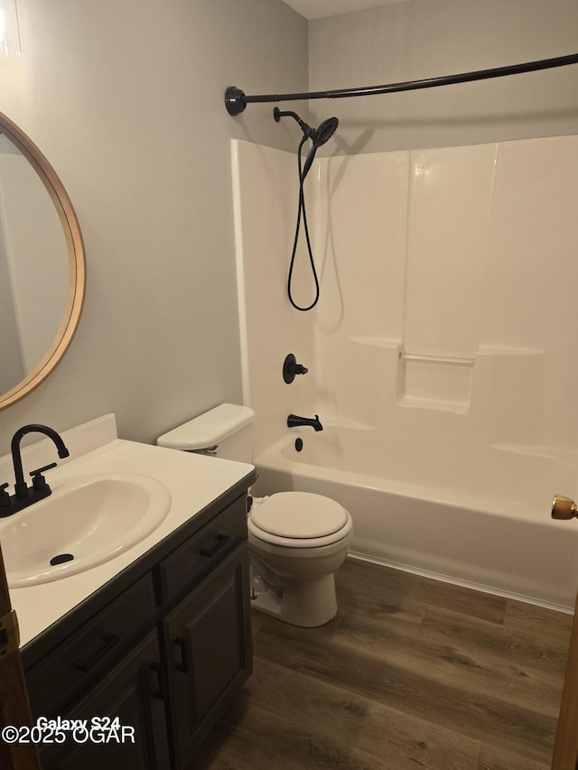 bathroom featuring toilet, shower / bath combination, wood finished floors, and vanity