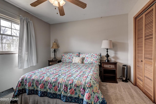 carpeted bedroom with a ceiling fan, baseboards, and a closet