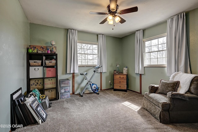 interior space featuring baseboards, a ceiling fan, and carpet