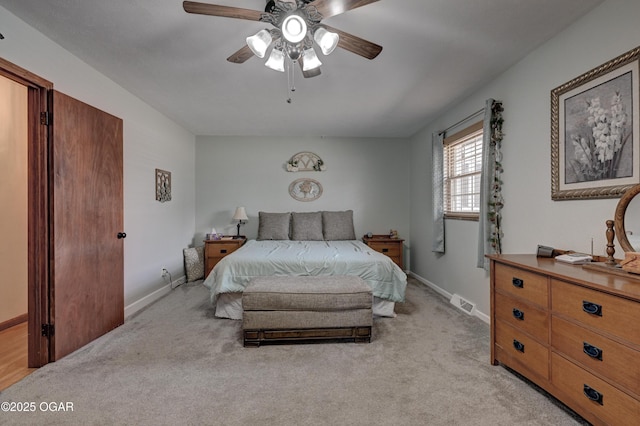 bedroom with baseboards, visible vents, light carpet, and ceiling fan